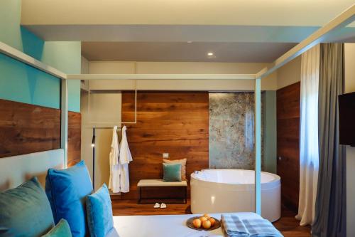a bathroom with a tub and a bed with blue pillows at Albergo La Pace in Segni