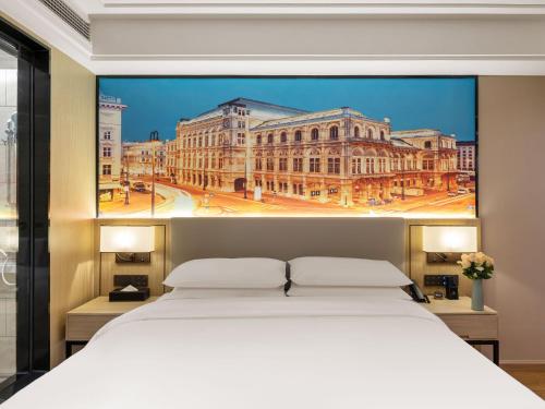 a bedroom with a large white bed in front of a building at Vienna International Hotel Xiamen Tong'an Industrial Concentration Area in Tong'an
