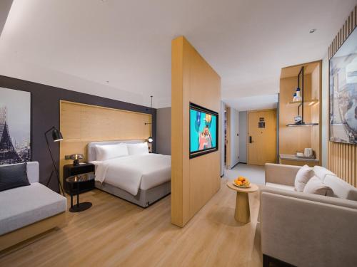 a hotel room with a bed and a couch at Park Inn by Radisson Chengdu Wuhou Shrine in Chengdu