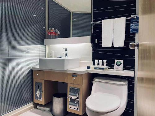 上海的住宿－Park Inn by Radisson Shanghai Downtown，浴室配有白色卫生间和盥洗盆。