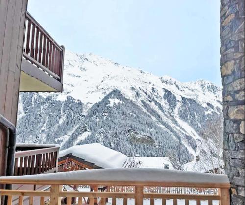 a balcony with a view of a snow covered mountain at Chalet Mélèze skis aux pieds Alpes, Sainte-Foy station 1550 in Sainte-Foy-Tarentaise