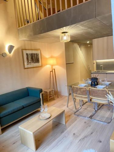 un salon avec un canapé bleu et une table dans l'établissement Chalet Mélèze skis aux pieds Alpes, Sainte-Foy station 1550, à Sainte-Foy-Tarentaise