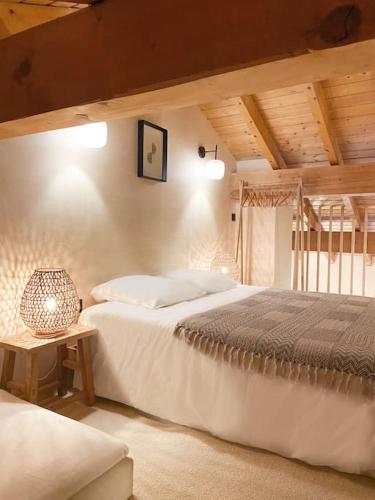 une chambre avec deux lits et une table avec une lampe dans l'établissement Chalet Mélèze skis aux pieds Alpes, Sainte-Foy station 1550, à Sainte-Foy-Tarentaise