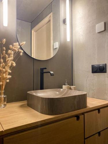 La salle de bains est pourvue d'un lavabo rond et d'un miroir. dans l'établissement Chalet Mélèze skis aux pieds Alpes, Sainte-Foy station 1550, à Sainte-Foy-Tarentaise