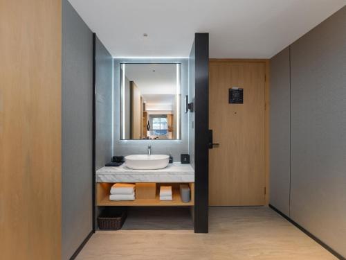 a bathroom with a sink and a mirror at Park Inn by Radisson Tianjin Jinghai Wanda Plaza in Jinghai