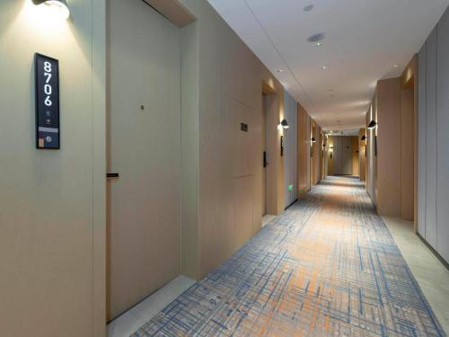 a hallway with a long corridor with a sign on a wall at Park Inn by Radisson Jilin Beishan Park&Songhua River in Jilin