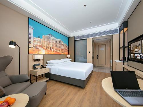 a hotel room with a large bed and a laptop at Vienna International Hotel Chengdu Shuangliu Airport Terminal Beijing Hualian in Chengdu