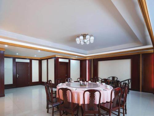 a dining room with a table and chairs at Vienna International Hotel FuJian PuTian Pearl in Putian
