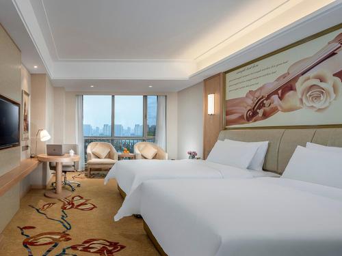Cette chambre comprend deux lits et une télévision. dans l'établissement Vienna International Hotel Hohhot High Speed Railway East Station, à Hohhot