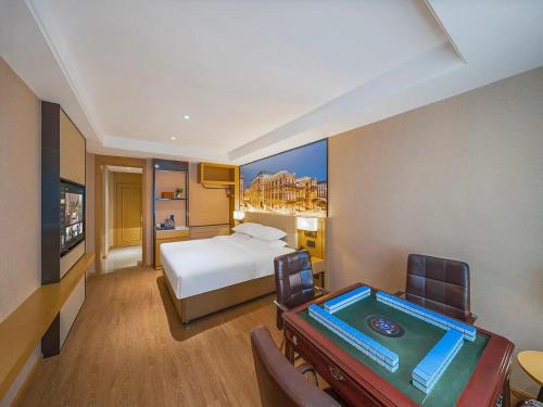 a hotel room with a bed and a pool table at Vienna International Hotel Kunming longquan road Finance University in Kunming