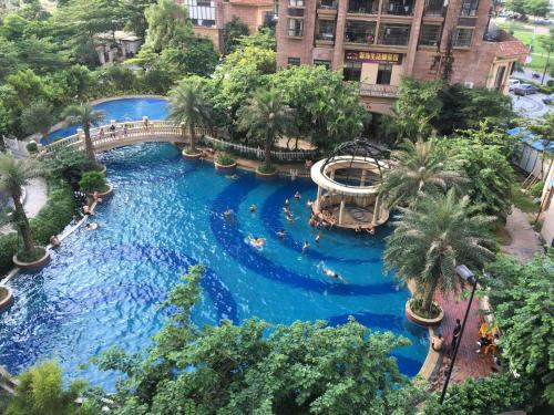 a large swimming pool with a bridge in a resort at Park Inn by Radisson Beihai Silver Beach Wanda Plaza in Beihai