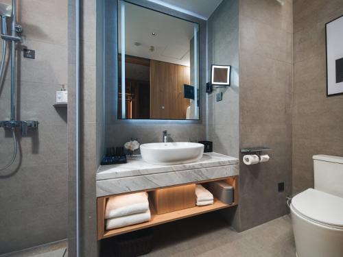 a bathroom with a sink and a toilet at Park Inn by Radisson Tianjin Five Old Street Nanjing Road in Tianjin