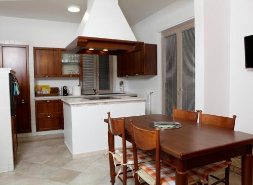 a kitchen with a wooden table with chairs and a sink at VILLA MARTINA PIA B&B in Filiano