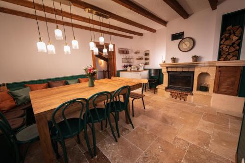 een eetkamer met een tafel en een open haard bij Home - Retour aux sources in Le Ménil