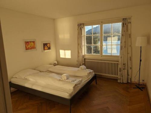 1 dormitorio con 2 camas y ventana en Charming house with a lake view en Lucerna