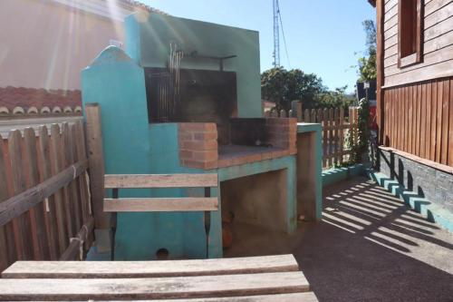 a outdoor grill with a wooden bench next to a fence at Cabañas Caudiel in Caudiel