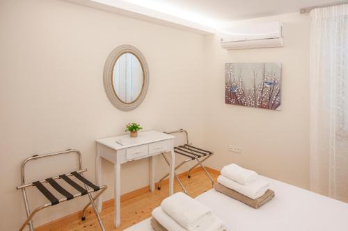 Cette chambre blanche dispose d'une table, de chaises et d'un miroir. dans l'établissement The Dreamy Loft Corfu, à Corfou