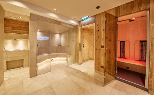 baño con ducha a ras de suelo y puerta de cristal en Hotel Gungau, en Saalbach Hinterglemm