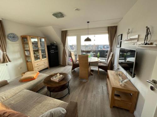 ein Wohnzimmer mit einem Sofa und einem Tisch in der Unterkunft Ferienwohnung Möwenschiss - Haus Bake in Büsum