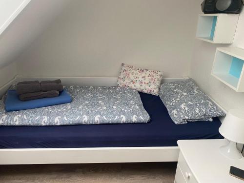 Bett in einem kleinen Zimmer mit zwei Kissen in der Unterkunft Ferienwohnung Möwenschiss - Haus Bake in Büsum