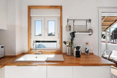 una cocina con fregadero y ventana en Varadero Beach Penthouse, en Los Caños de Meca