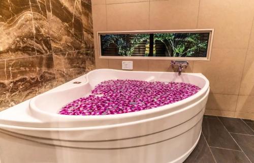 a bath tub covered in pink flowers in a bathroom at BaliAn Resort Forest Ikebukuro in Tokyo