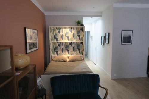 - une chambre avec un lit avec une tête de lit et une chaise dans l'établissement Le Diffonty Cosy Vintage centre Historique, à La Ciotat