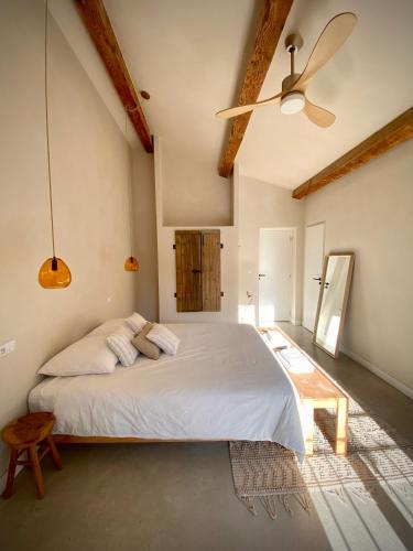 a bedroom with a large bed and a ceiling fan at Felix - Maison d'hôtes in Néffiès