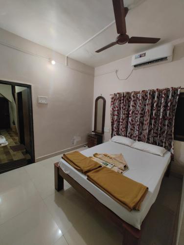 a bedroom with a bed and a ceiling fan at Konkan Villa Dream in Malvan