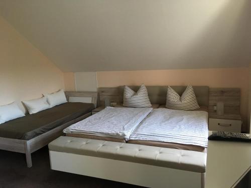 een slaapkamer met 2 bedden met witte lakens en kussens bij Landhaus Böhmer, Ferienhaus Schrammsteinblick in Kurort Gohrisch