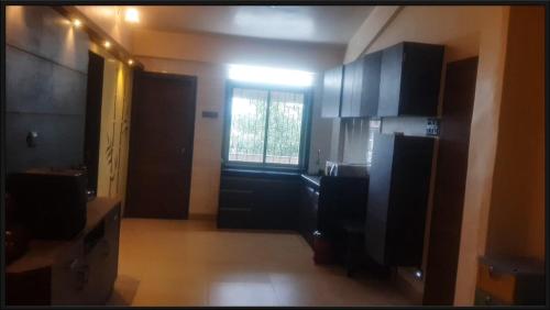 a kitchen with black cabinets and a window at 2bhk Apartment with 1900sq ft Private Terrace in Lonavala in Malavli
