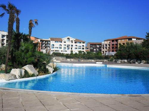une grande piscine avec des bâtiments en arrière-plan dans l'établissement GASRIAN - Meublé de tourisme classé 3 étoiles, avec accès plage et piscine, à Gassin