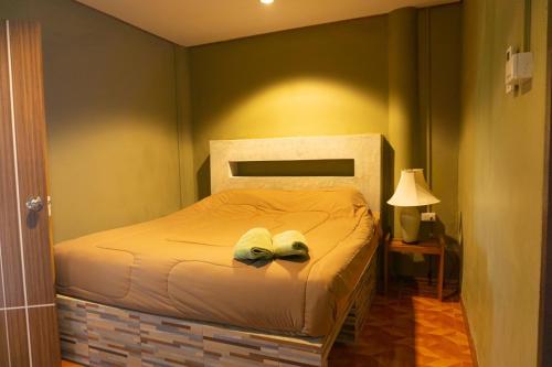 a bedroom with a bed with two shoes on it at Kwainoy Riverpark in Sai Yok