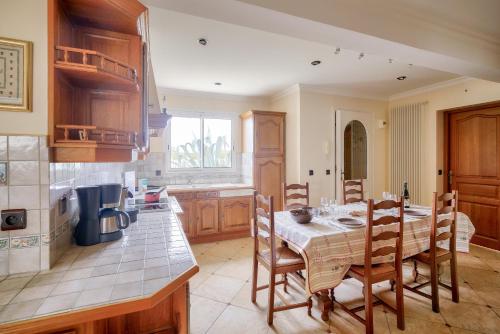 - une cuisine avec une table, des chaises et une table dans l'établissement Grande maison vue mer au Guilvinec, au Guilvinec