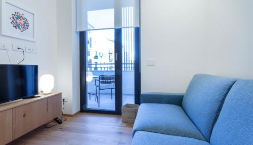 a living room with a blue couch and a television at Italianway - Cecchi 18 in Milan