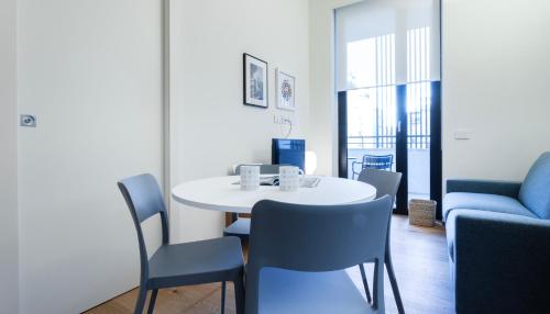 a dining room with a white table and blue chairs at Italianway - Cecchi 18 in Milan