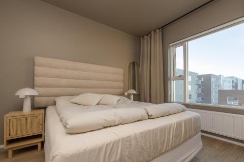 1 dormitorio con 1 cama grande y ventana grande en Modern flat in Reykjavík, Úlfarsárdalur, en Reikiavik