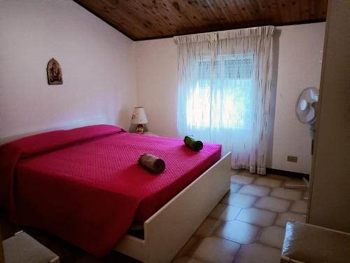 ein Schlafzimmer mit einem roten Bett und einem Fenster in der Unterkunft villa modica casteltermini in Casteltermini