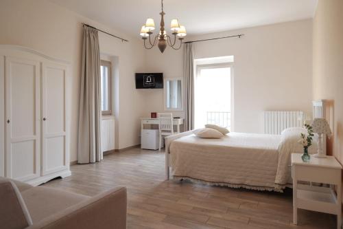 ApiceにあるAgriturismo Villa Luisaの白いベッドルーム(ベッド1台、ソファ付)