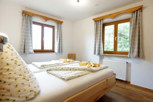 two beds in a room with two windows at Wagnerhof in Au am Inn