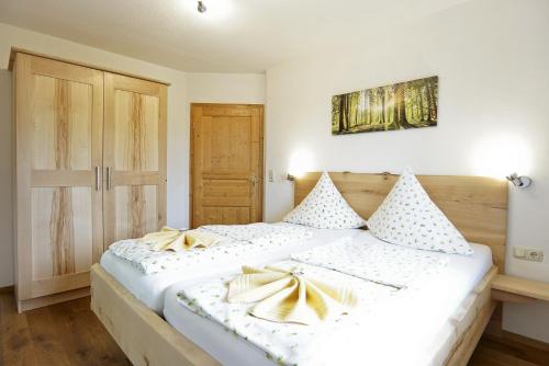a bedroom with a large white bed with gold bows at Wagnerhof in Au am Inn