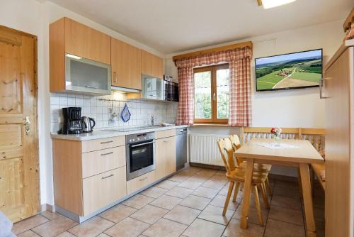 a kitchen with a table and a dining room at Wagnerhof in Au am Inn