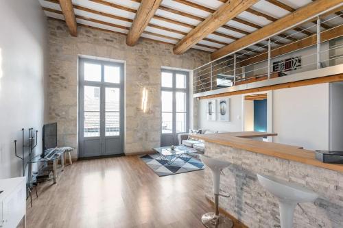 une cuisine avec un bar et un salon dans l'établissement Loft d’exception 67 m2 av balcon sans vis à vis, à Montpellier