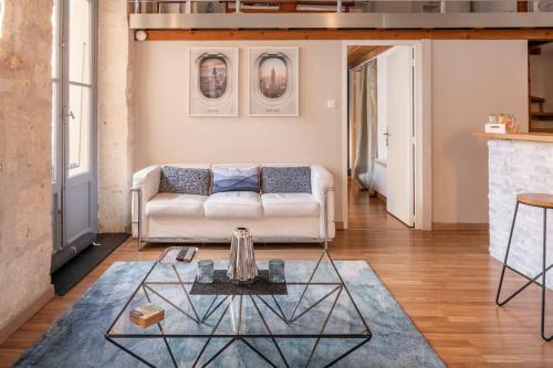 un salon avec un canapé blanc et une table en verre dans l'établissement Loft d’exception 67 m2 av balcon sans vis à vis, à Montpellier