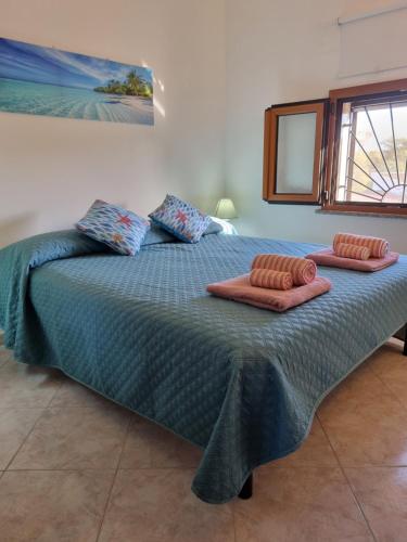 1 dormitorio con 1 cama grande y 2 almohadas en Villa Maddalena guest house, en Sorso