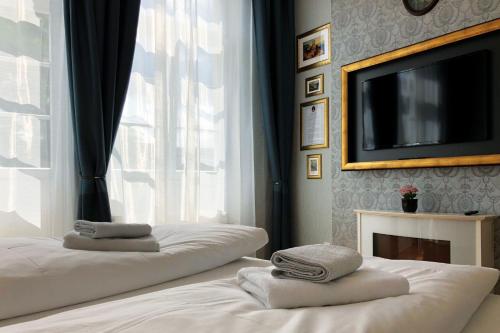 a bedroom with two beds with a tv and a window at Hotel Kleiner Riesen in Koblenz