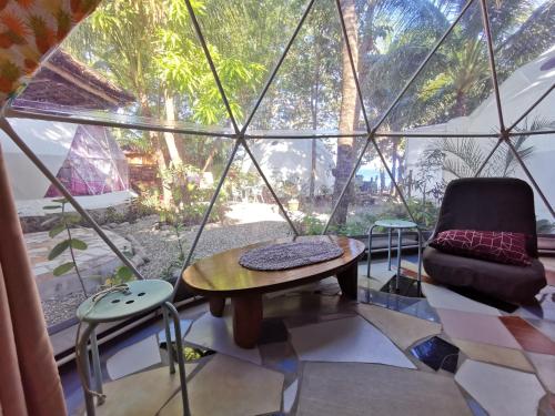 une chambre avec une table, une chaise et une fenêtre dans l'établissement Glamping Dome Dauin Beach and Dive Resort, à Dauin