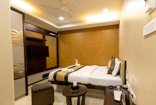 a hotel room with a bed and a tv at The Majlis Hotel - Colaba Mumbai in Mumbai