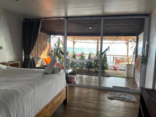 a bedroom with a bed and a view of the ocean at Namthip Homebeach in Baan Tai
