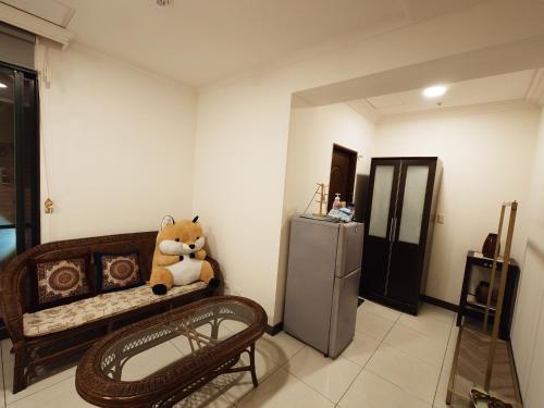 a teddy bear sitting on a bed in a room at Cat5 Mewo Meow House in Taipei